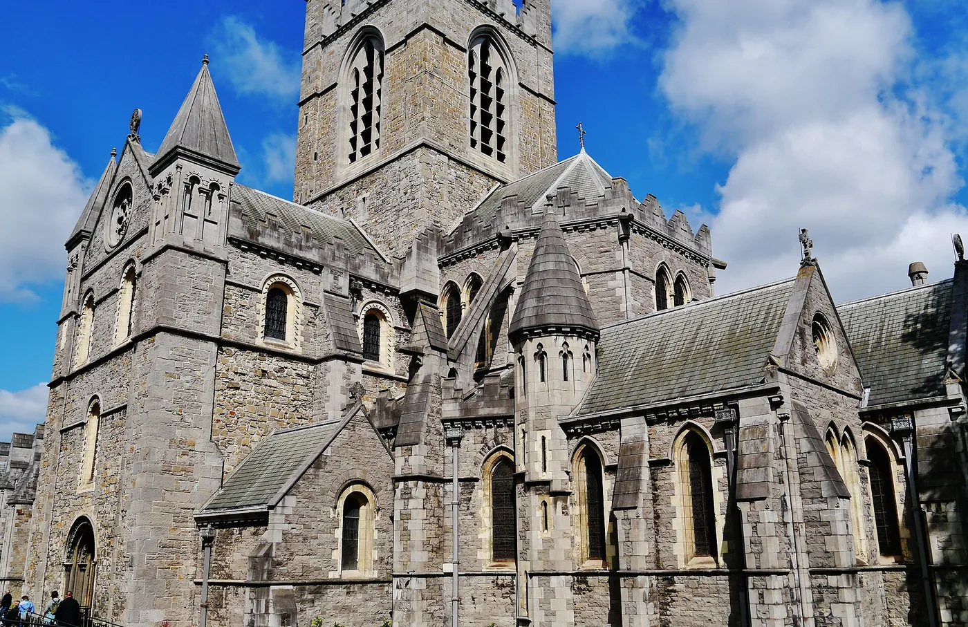 The tower and stone walls of Christ Church Cathedral in Dublin under a blue sky
